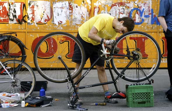 多伦多自行车公司的丹·t在肯辛顿市场修理自行车